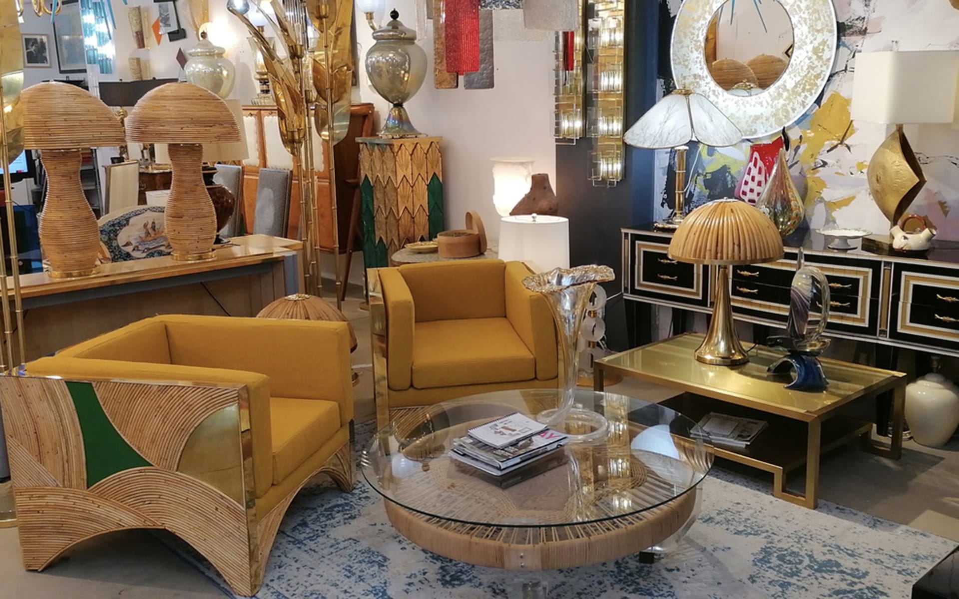 Vintage furniture showroom with yellow chairs, glass coffee table, and eclectic decor elements.