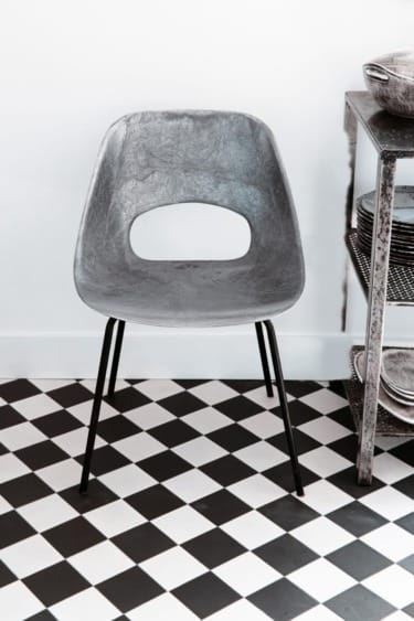 The 1950s chair by Pierre Guariche, photographed in Rozensztroch’s apartment, is an example of the type of finds he looks for in antiques markets, to be sold at Merci.