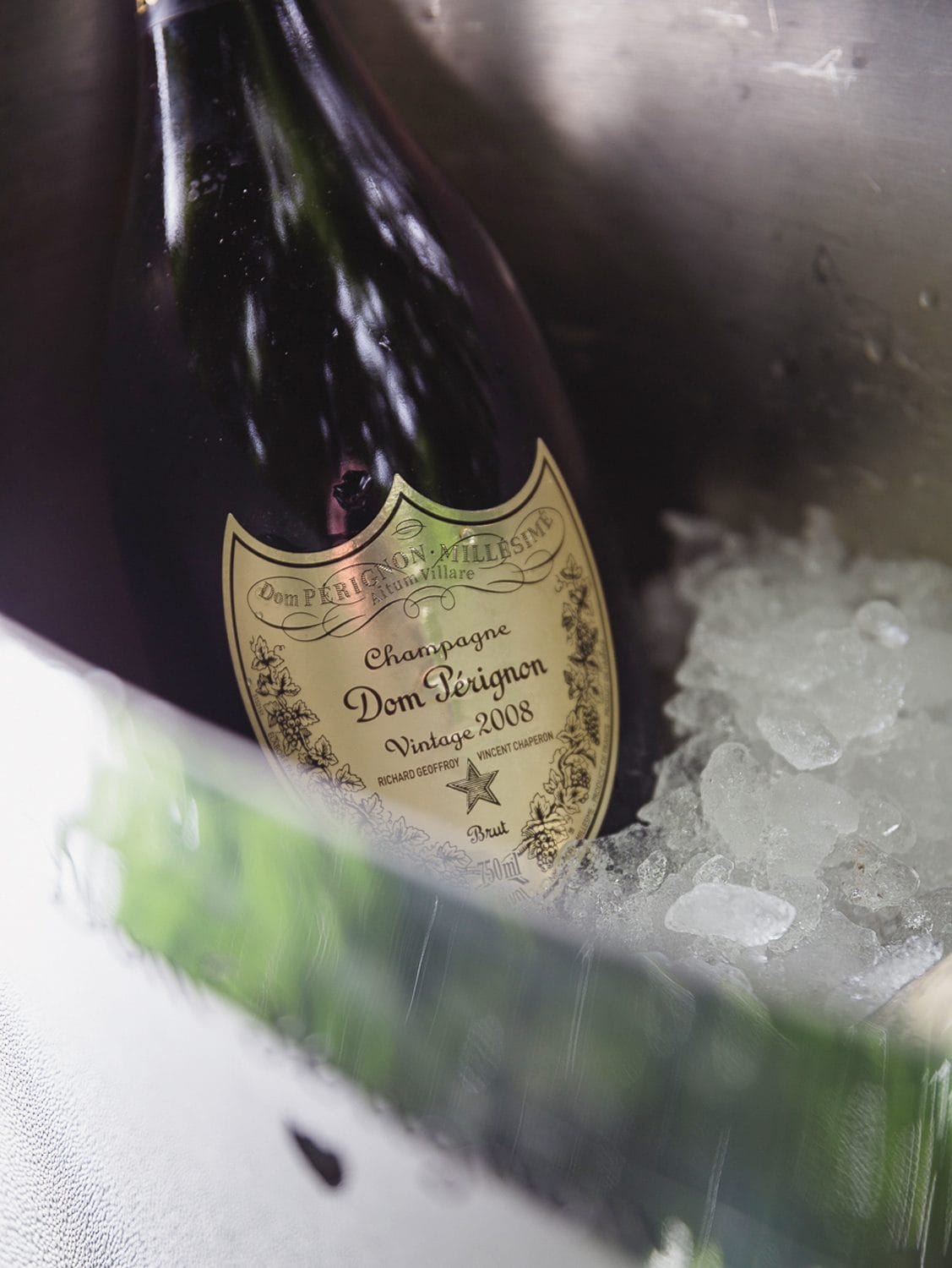 Bottle of Dom Pérignon 2008 champagne chilling in a metal ice bucket.