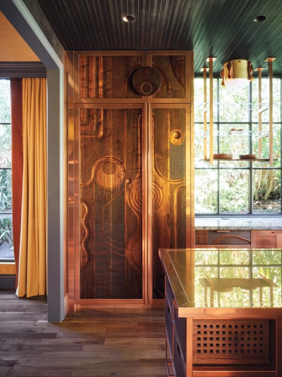 Lights by Jeremy Anderson glow against a ceiling embellished by decorative artist Caroline Lizarraga.