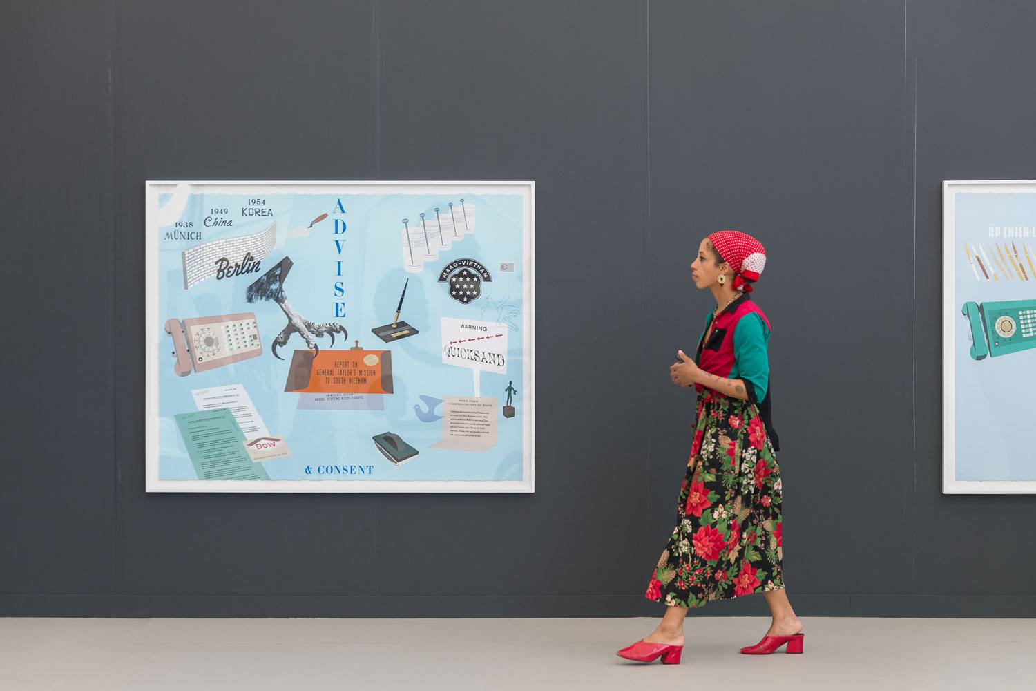 Woman in a floral dress and red shoes walking past colorful artwork on a gallery wall.