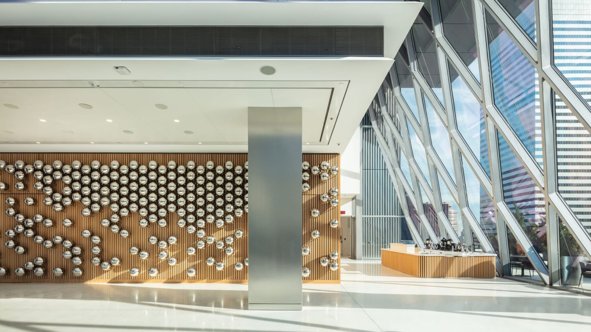 Modern lobby with a geometric wall design and large windows allowing natural light to illuminate the space