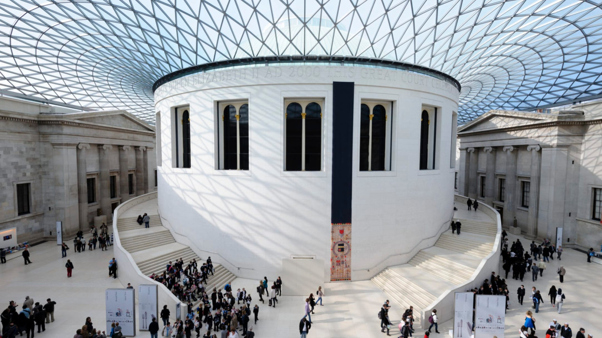 Interior view of the British Museum's Great Court with people walking and the glass roof above.