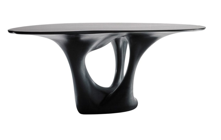 Sleek black sculptural table with an artistic, flowing base and an oval top.
