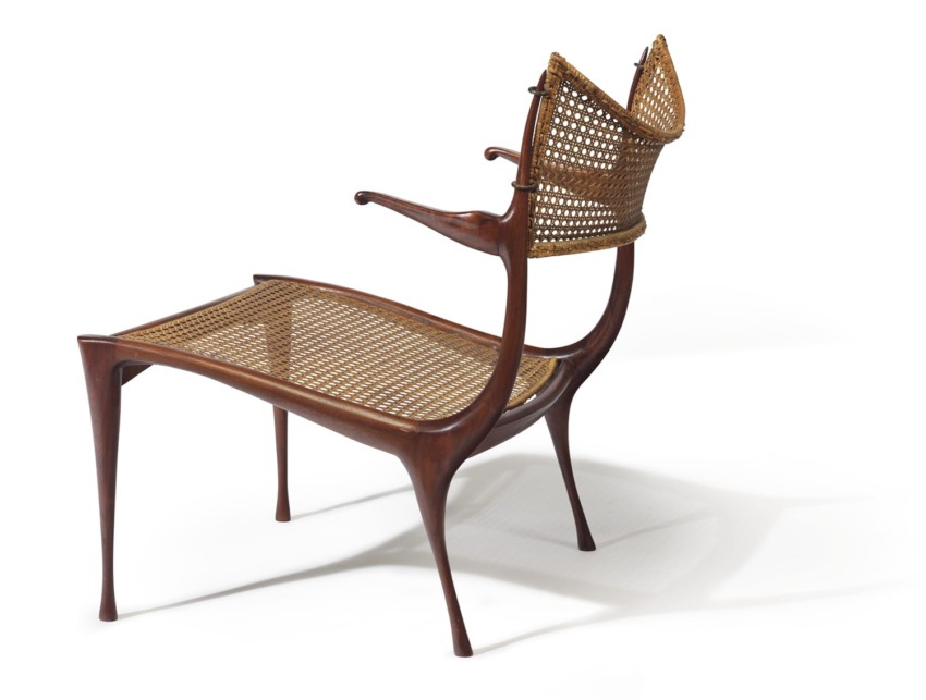 Mid-century modern wooden chair with woven cane backrest and seat on a clean white background.