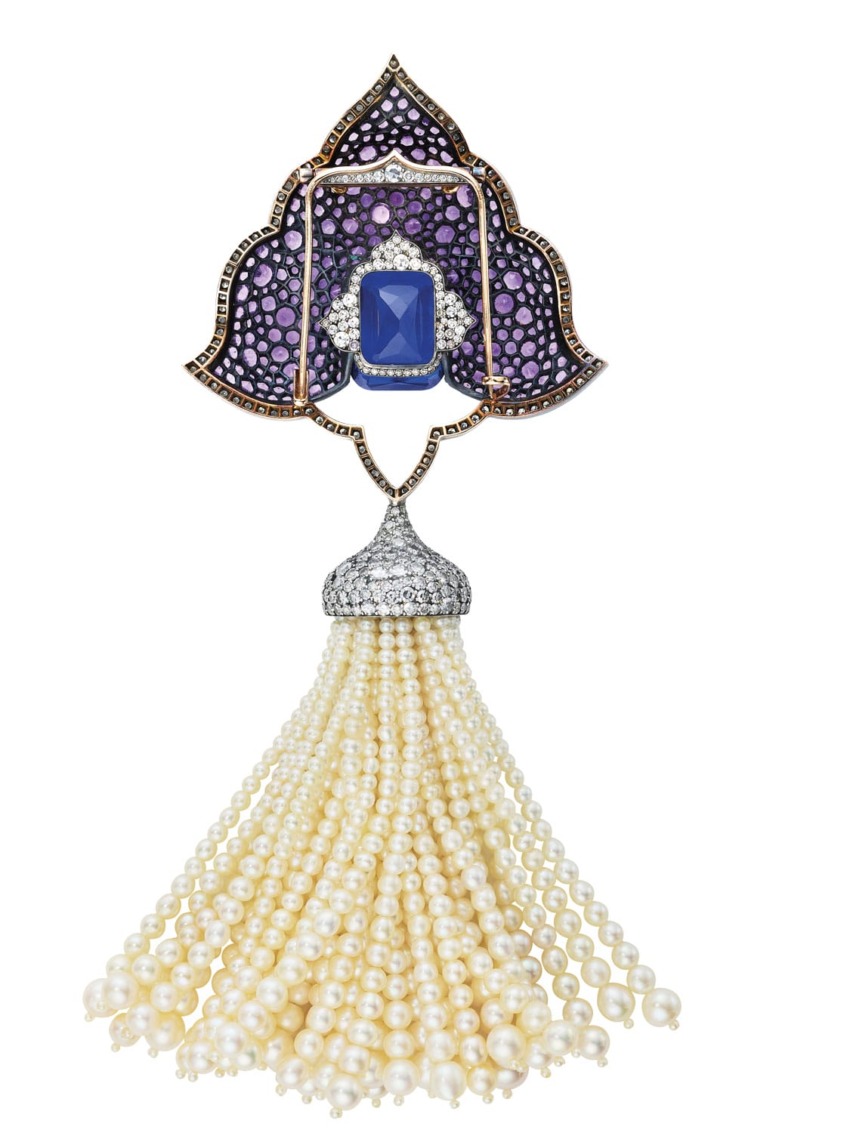 Ornate jeweled pendant with pearls, featuring purple and blue gemstones in an intricate design.