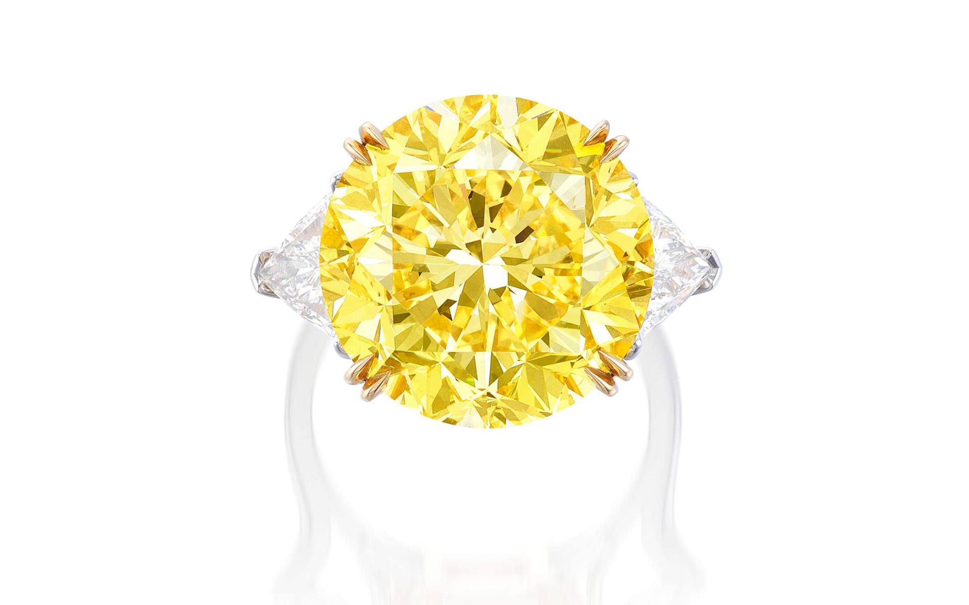 Yellow diamond ring with white triangular side stones and a white band, displayed on a white background.