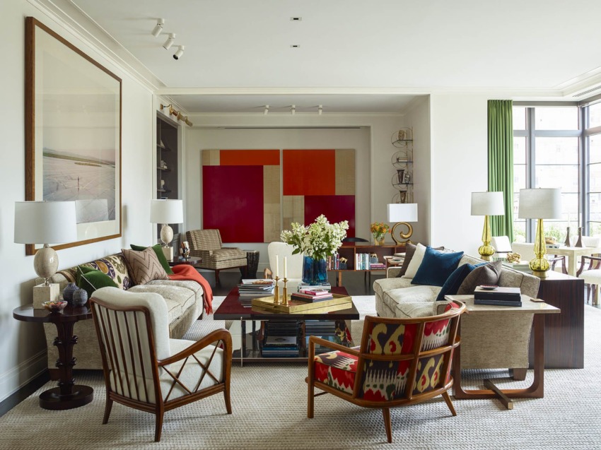 Modern living room with colorful artwork, comfortable seating, coffee table, and large windows allowing natural light.