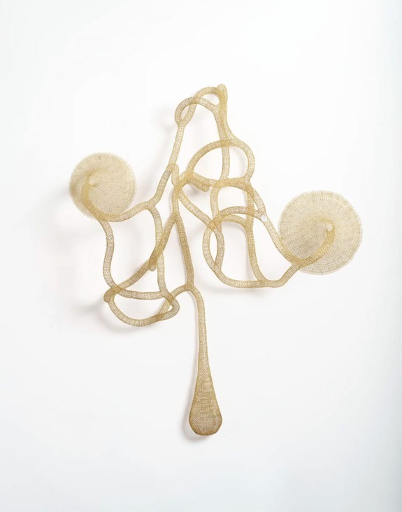 Abstract metal sculpture with intertwined loops and circular patterns against a white background.