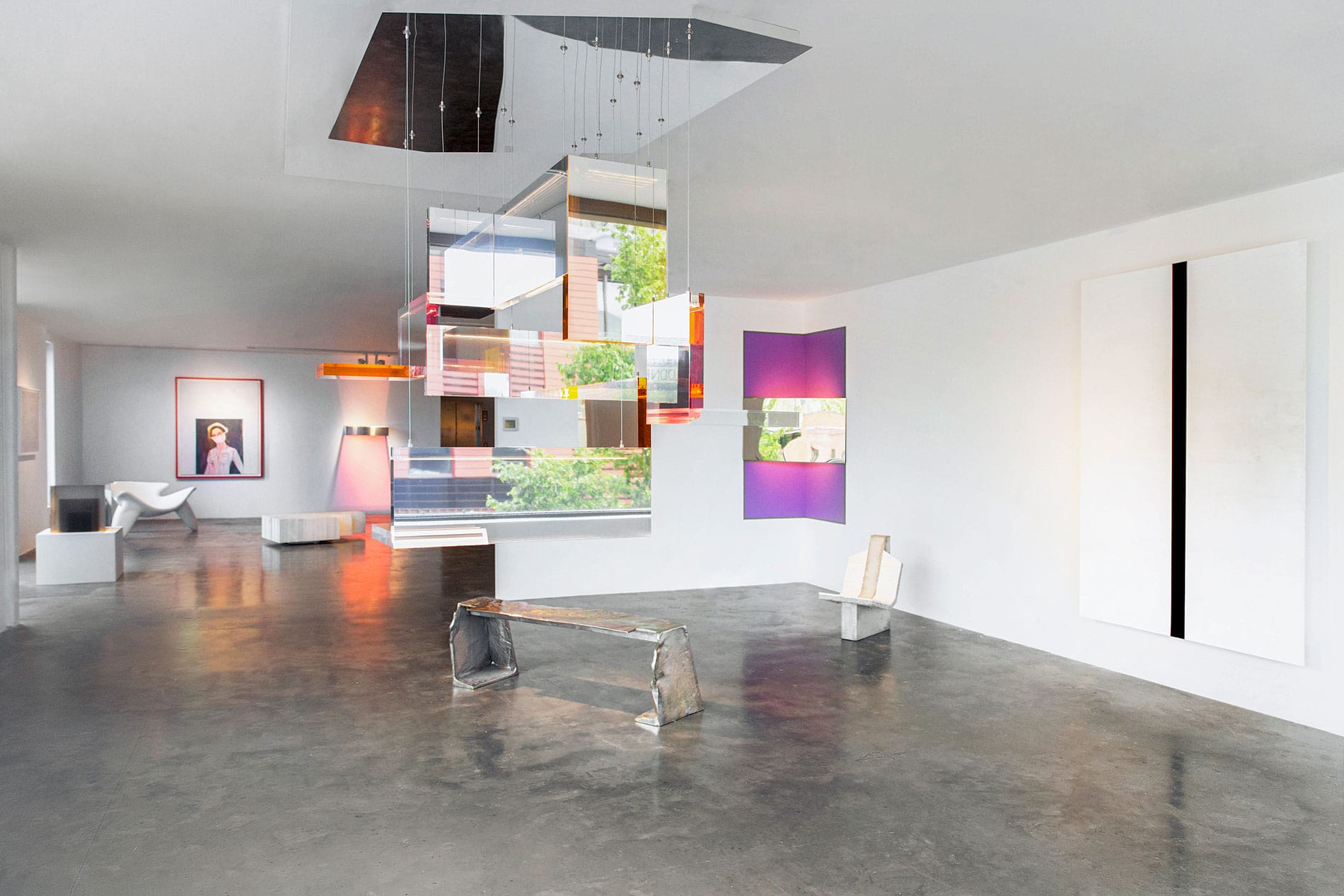 Modern art gallery interior with contemporary installations, colorful abstract paintings, and sleek minimalist furniture.
