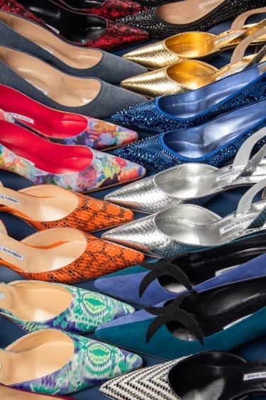 A colorful assortment of women's high-heeled shoes with various patterns and materials arranged in rows.