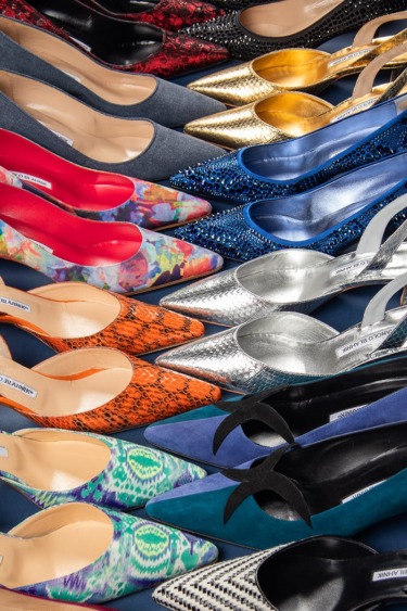 A colorful assortment of women's high-heeled shoes with various patterns and materials arranged in rows.