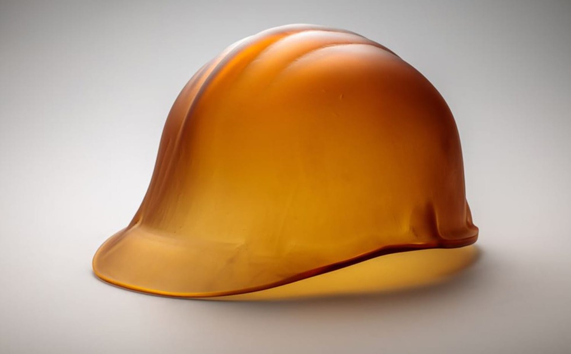 Translucent amber hard hat with soft lighting and a smooth surface, set against a neutral background.