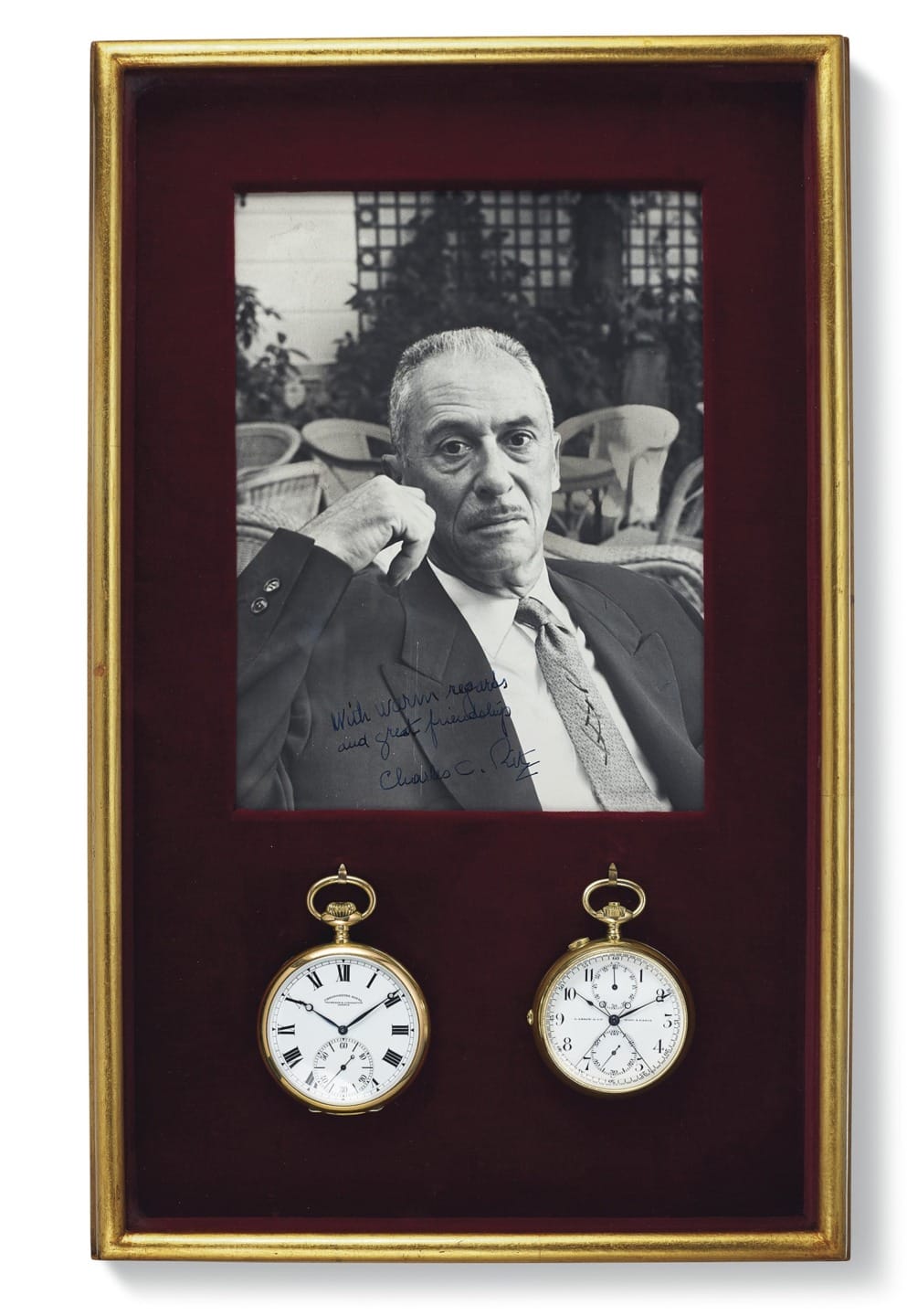 Framed black-and-white portrait of a seated man with two pocket watches displayed below the photo.