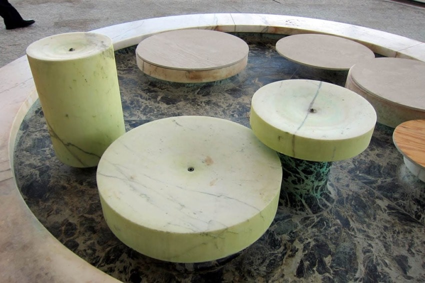 Circular marble sculptures of varying heights and sizes on a dark stone base.