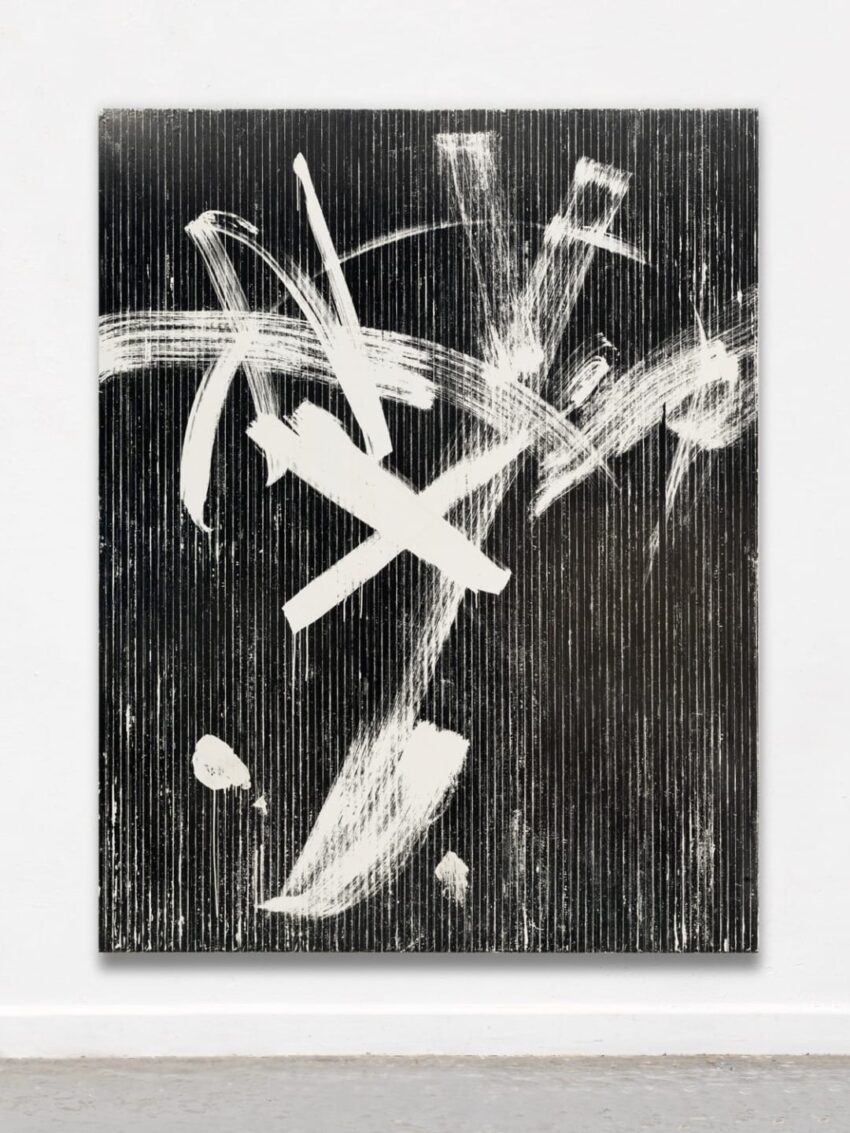 Abstract black and white painting featuring dynamic brushstrokes and textured vertical lines displayed in a gallery setting.