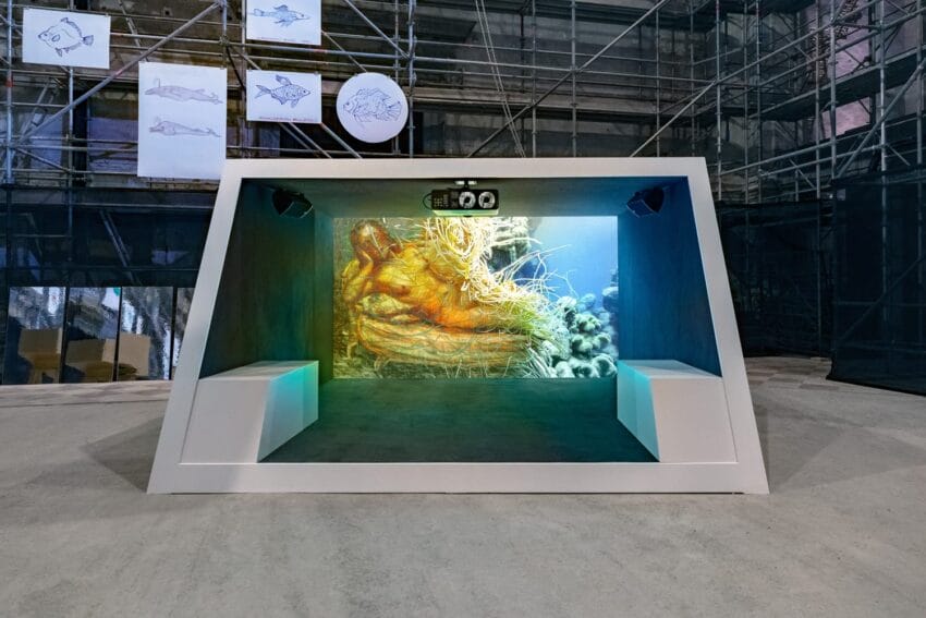 Aquarium exhibit with underwater projection, scaffolding background, and fish illustrations on display.