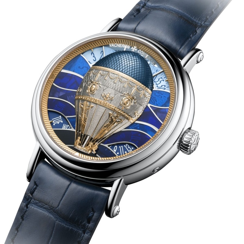 Luxurious wristwatch with ornate hot air balloon design on dial, featuring blue and silver accents and a blue leather strap.