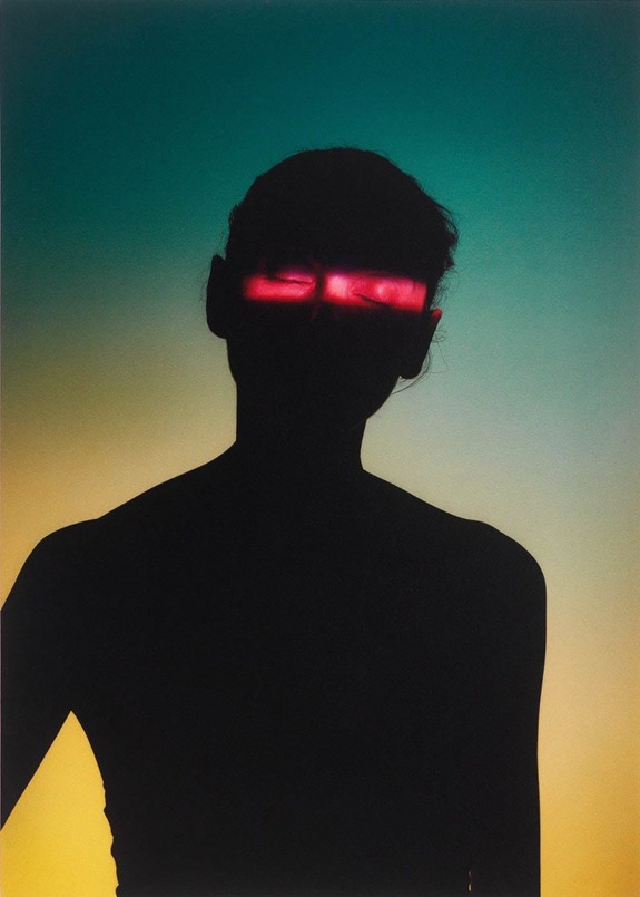 Silhouette of a person against a gradient background with glowing red light across eyes.