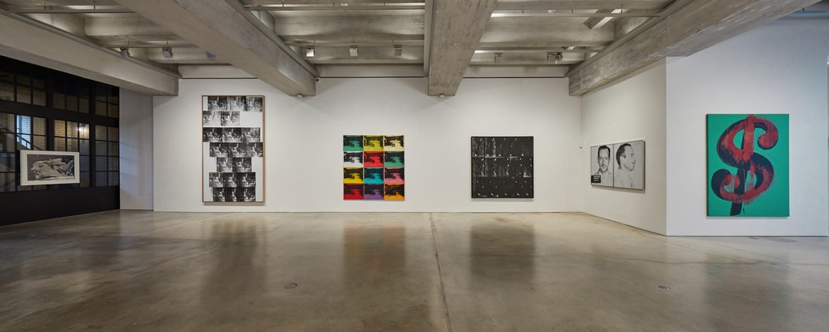 modern art gallery with paintings on walls including abstract designs, portraits, and dollar sign symbol