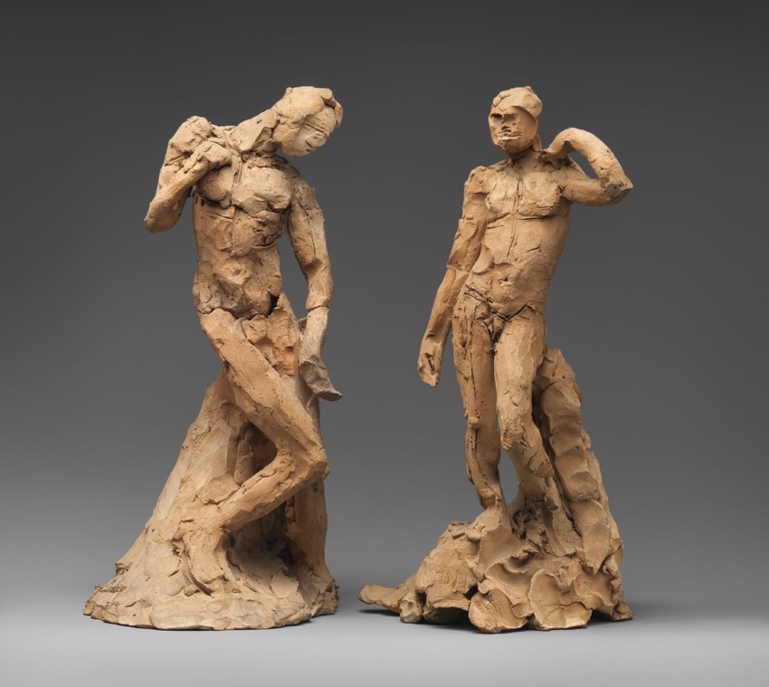 Two clay sculptures of human figures with rough textures, posed in dynamic positions against a neutral gray background.