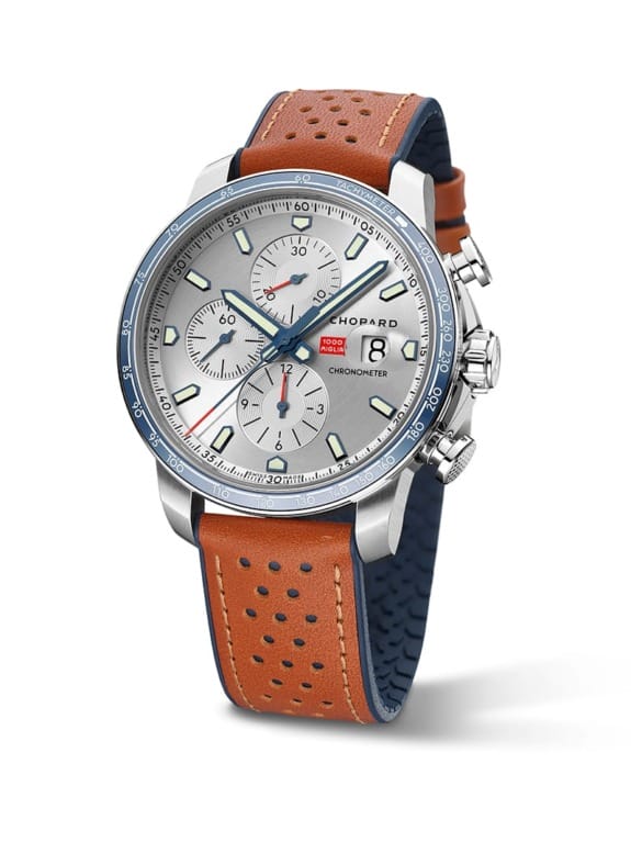 Luxury Chopard chronometer with a silver dial, blue and brown stopwatch features, and a perforated brown leather strap.