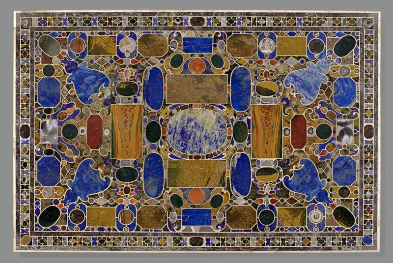 Intricate geometric marble inlay tabletop featuring colorful stones and symmetrical patterns, reflecting classic artistry.