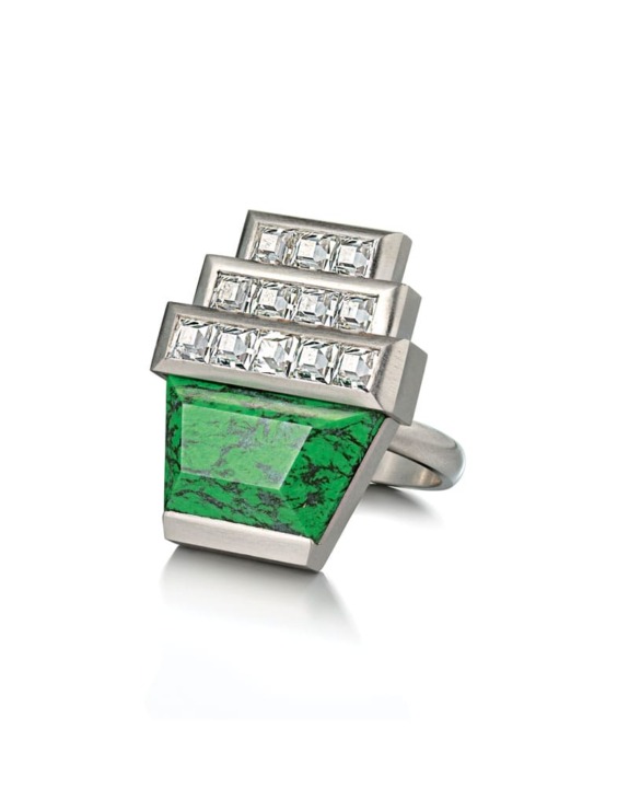 Silver ring with a large green gemstone and multiple square white stones arranged in a stepped design.