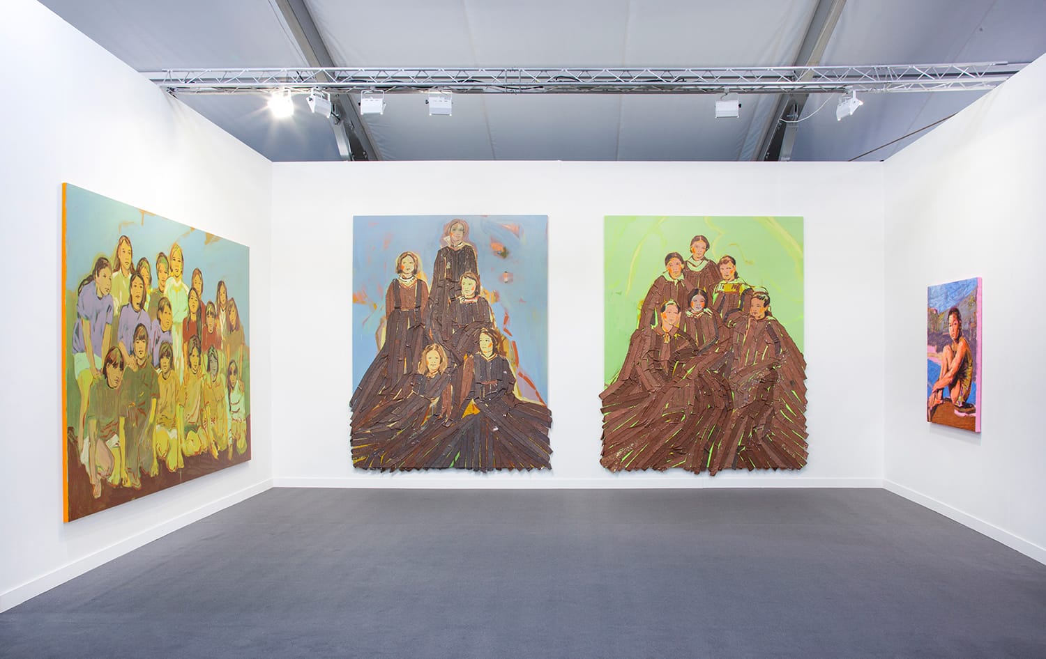 Art gallery with vibrant paintings depicting groups of people displayed on white walls, under bright exhibition lighting.