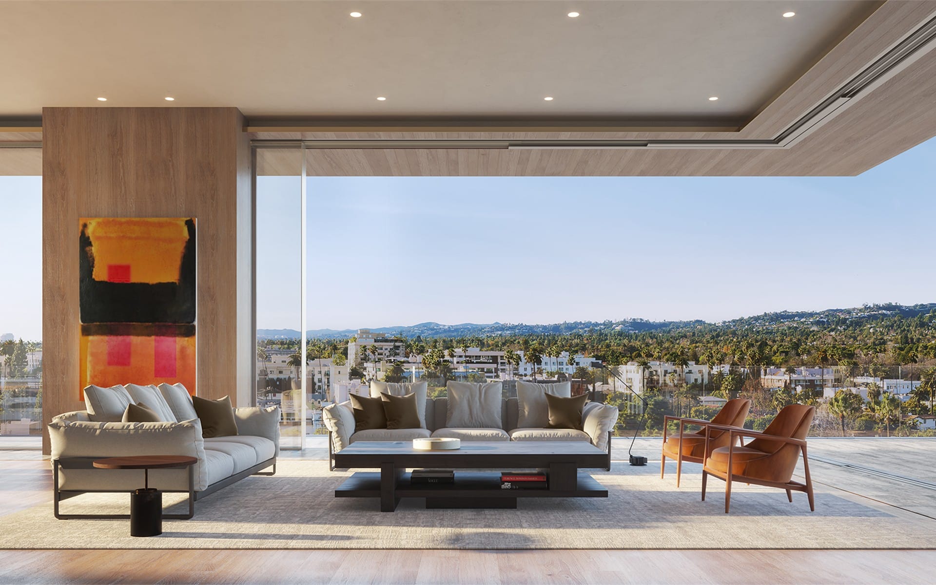 Modern living room with large windows, neutral-toned furniture, colorful wall art, overlooking a cityscape and lush greenery.