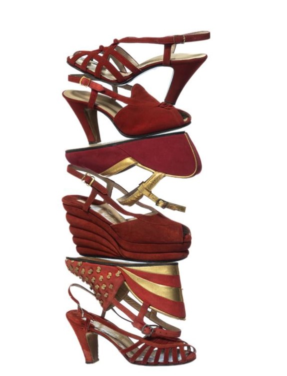 A stack of five red high-heeled shoes in different styles, showcasing various designs and textures in a vertical arrangement.