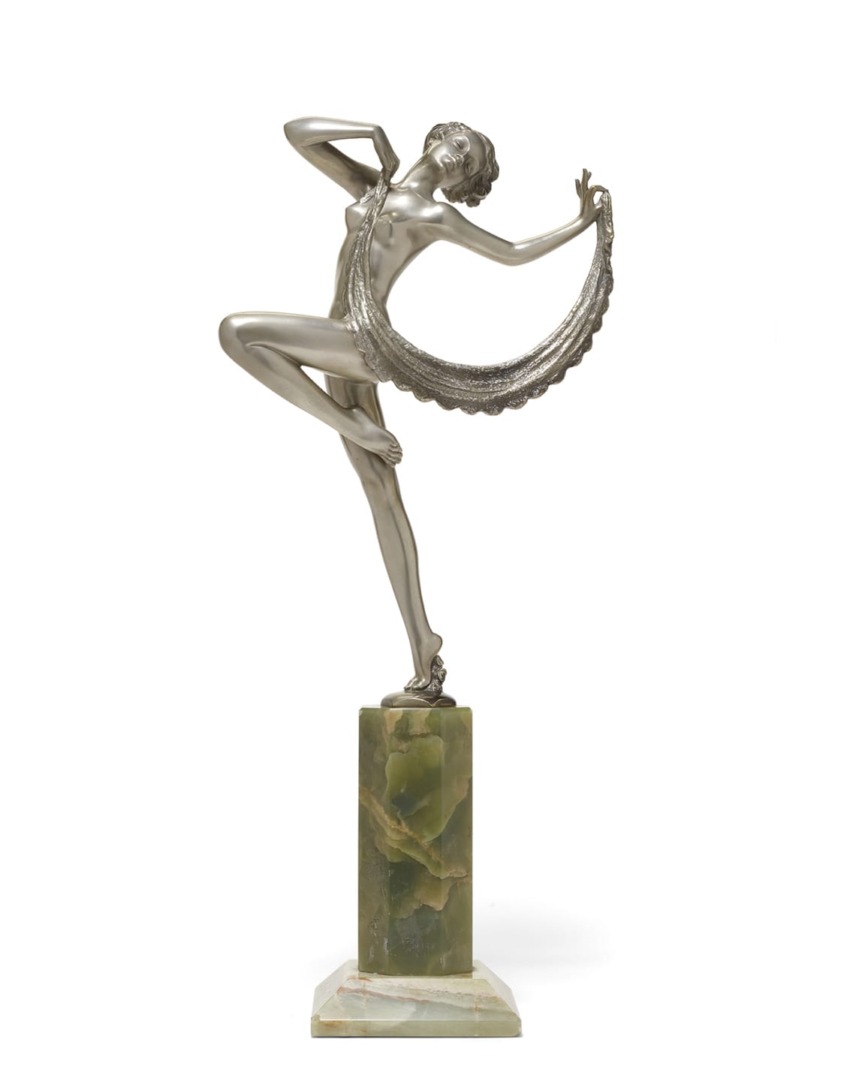 Art deco style sculpture of a dancing woman on a green marble base, holding a flowing drape in an elegant pose.
