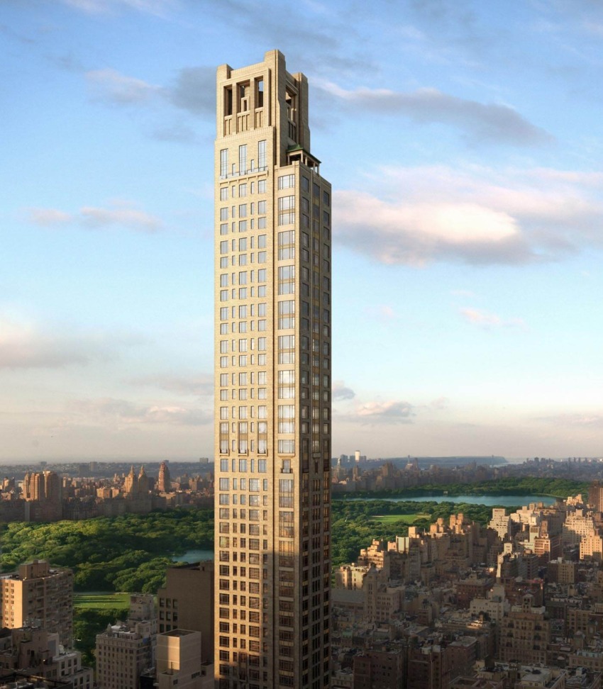 Tall skyscraper overlooking Central Park with a clear blue sky in the background.