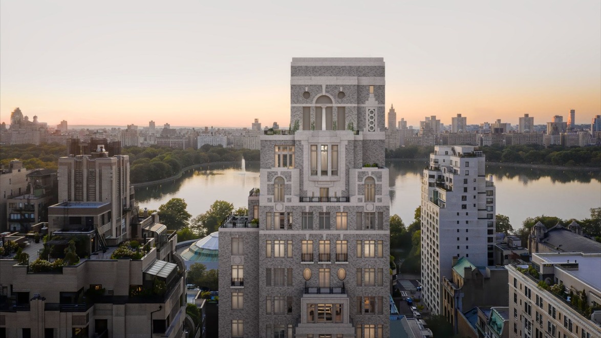 View of a city skyline at sunset with a focus on an ornate building and a river in the background.