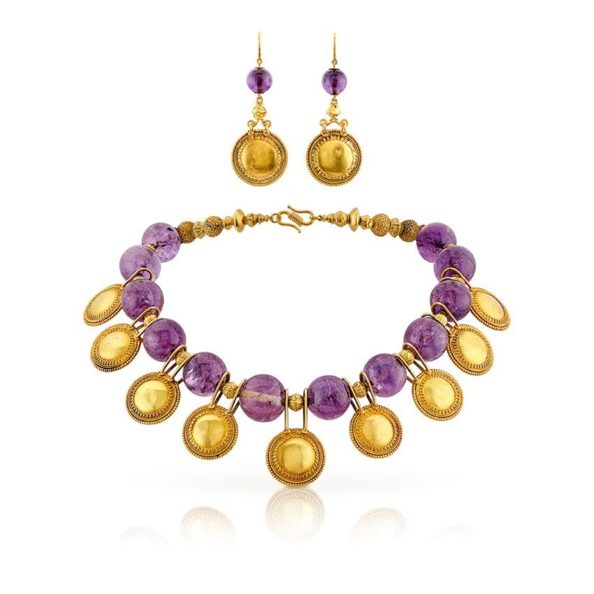Gold and amethyst bead necklace with matching dangling earrings displayed on a white background.