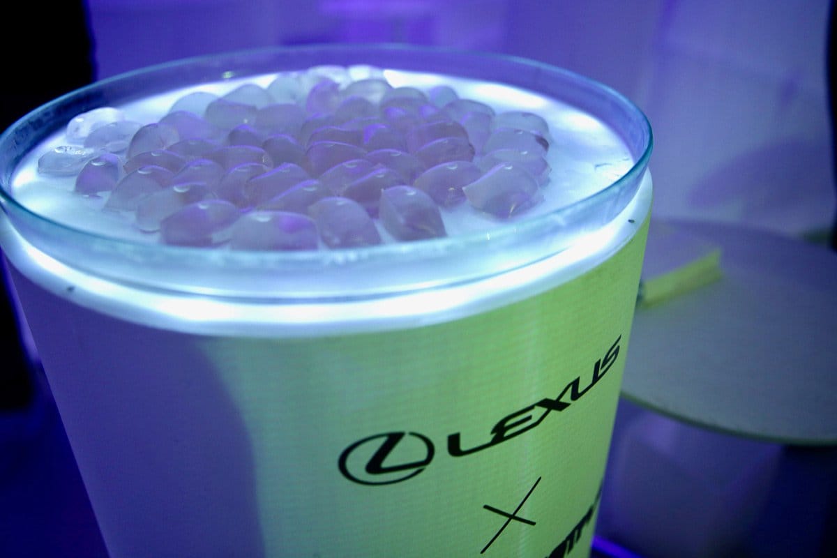 Glass bowl with ice cubes on glowing stand, featuring the Lexus logo.