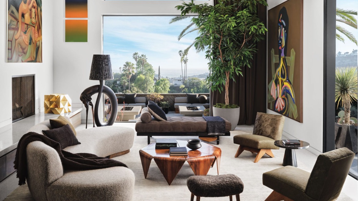 Modern living room with chic furniture, large window view, abstract art, and indoor plant, overlooking a scenic landscape.