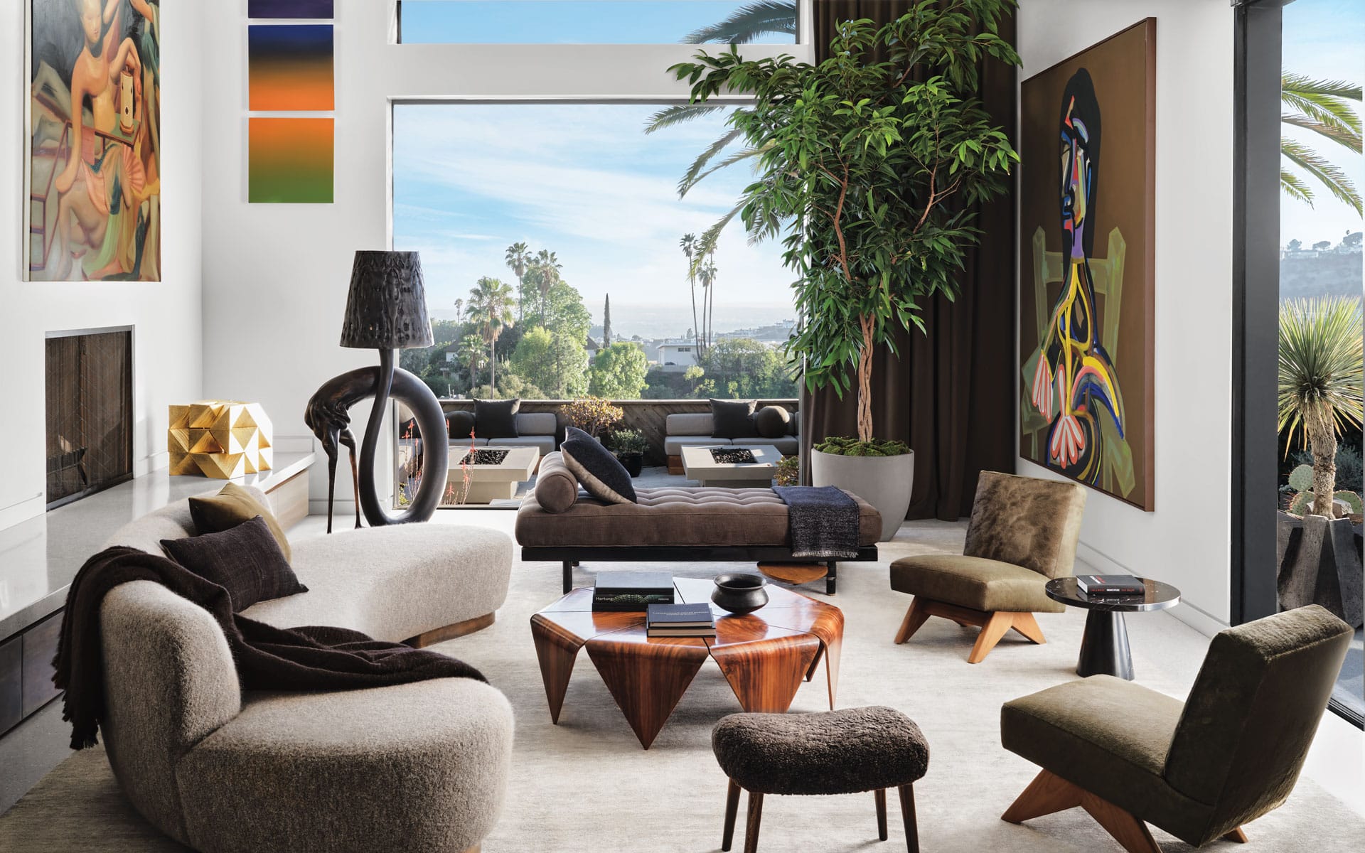Modern living room with chic furniture, large window view, abstract art, and indoor plant, overlooking a scenic landscape.
