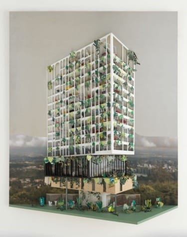Model of a modern building surrounded by plants and greenery against a hazy skyline background.