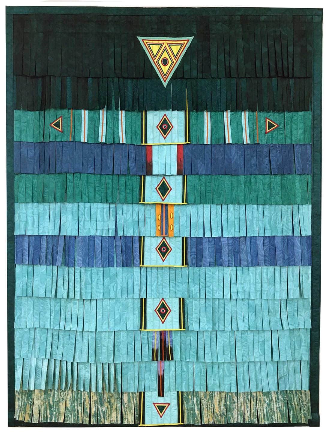 Textile artwork with geometric patterns featuring triangles and diamonds in shades of blue, teal, and green.