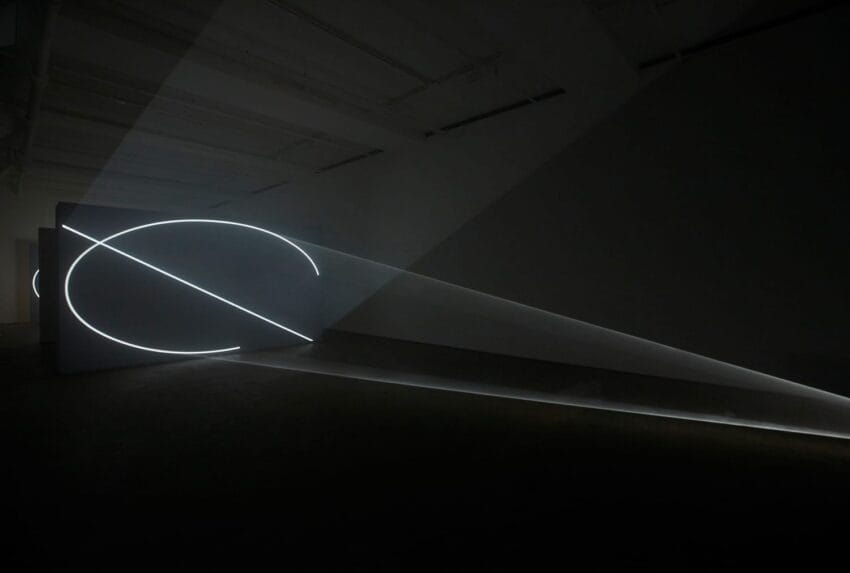 glowing geometric light installation on dark walls in an art gallery
