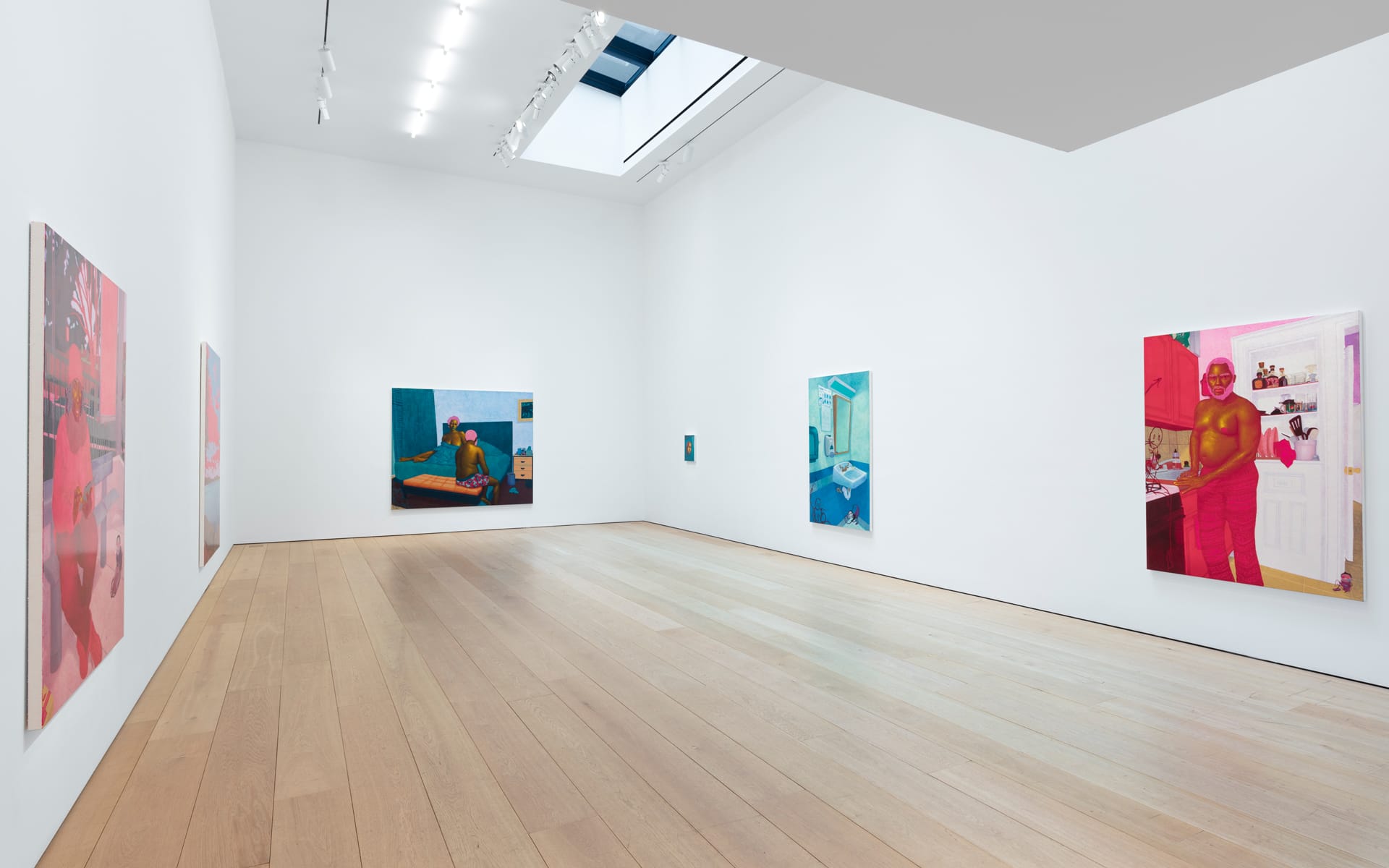 Art gallery with colorful paintings on white walls, wooden floor, skylight ceiling, and soft lighting.