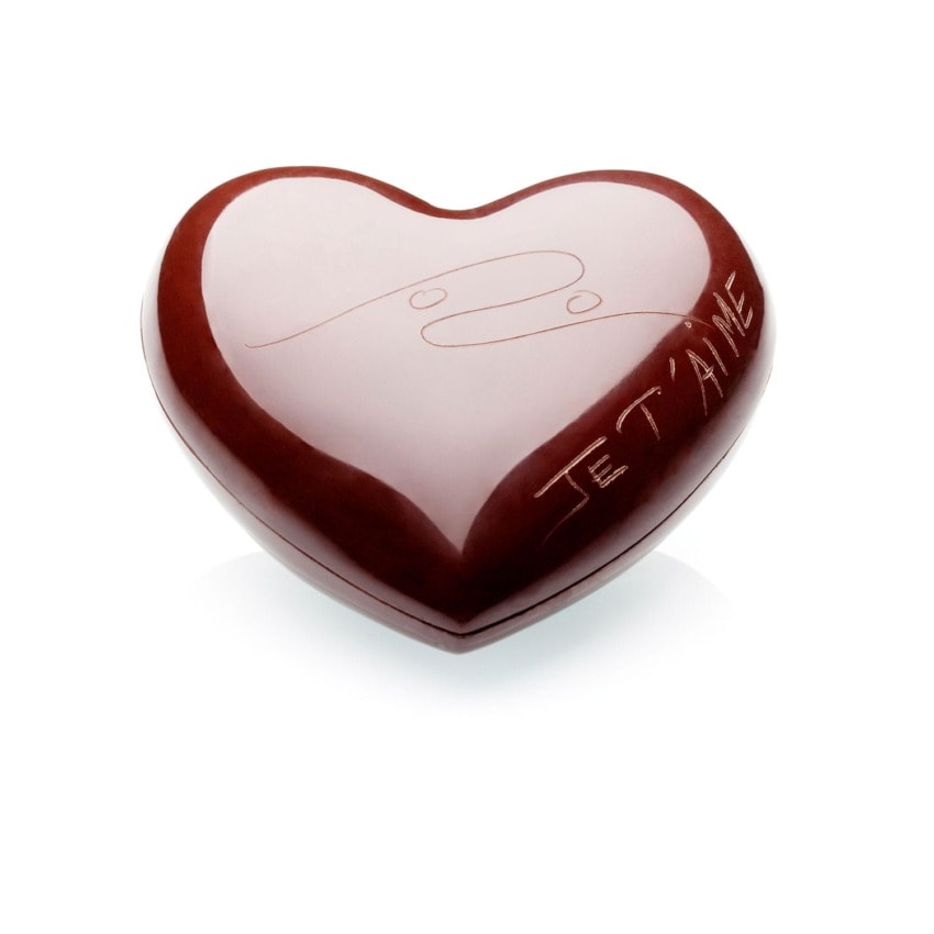 Heart-shaped chocolate with "Je T'aime" engraved on the side, featuring a shiny, smooth surface.