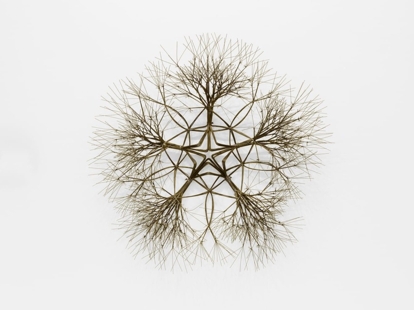 Intricate wire sculpture resembling a tree, with multiple branches extending symmetrically in a circular pattern.