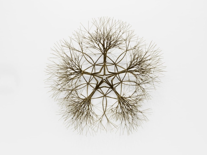 Intricate wire sculpture resembling a tree, with multiple branches extending symmetrically in a circular pattern.