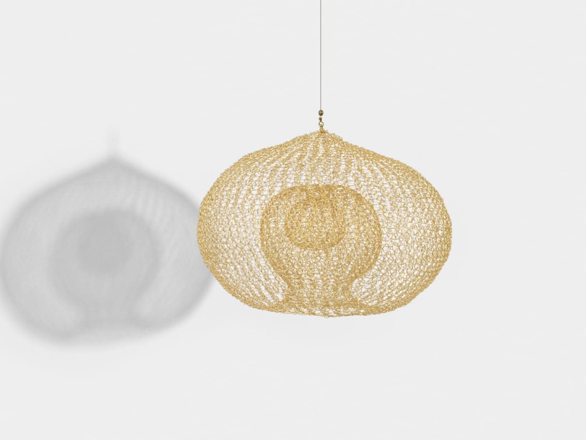 Golden wire mesh hanging lamp with intricate circular design casting shadow on a plain white background.