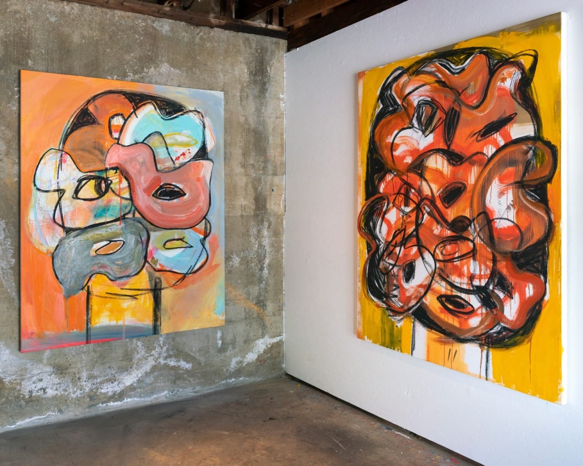 Two abstract paintings with vibrant colors and bold brushstrokes displayed on concrete and white walls in a gallery setting.