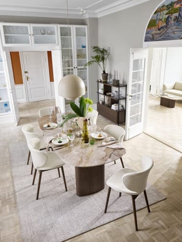 Modern dining room with a marble table, elegant chairs, and a hanging pendant light, next to open shelves and large windows.