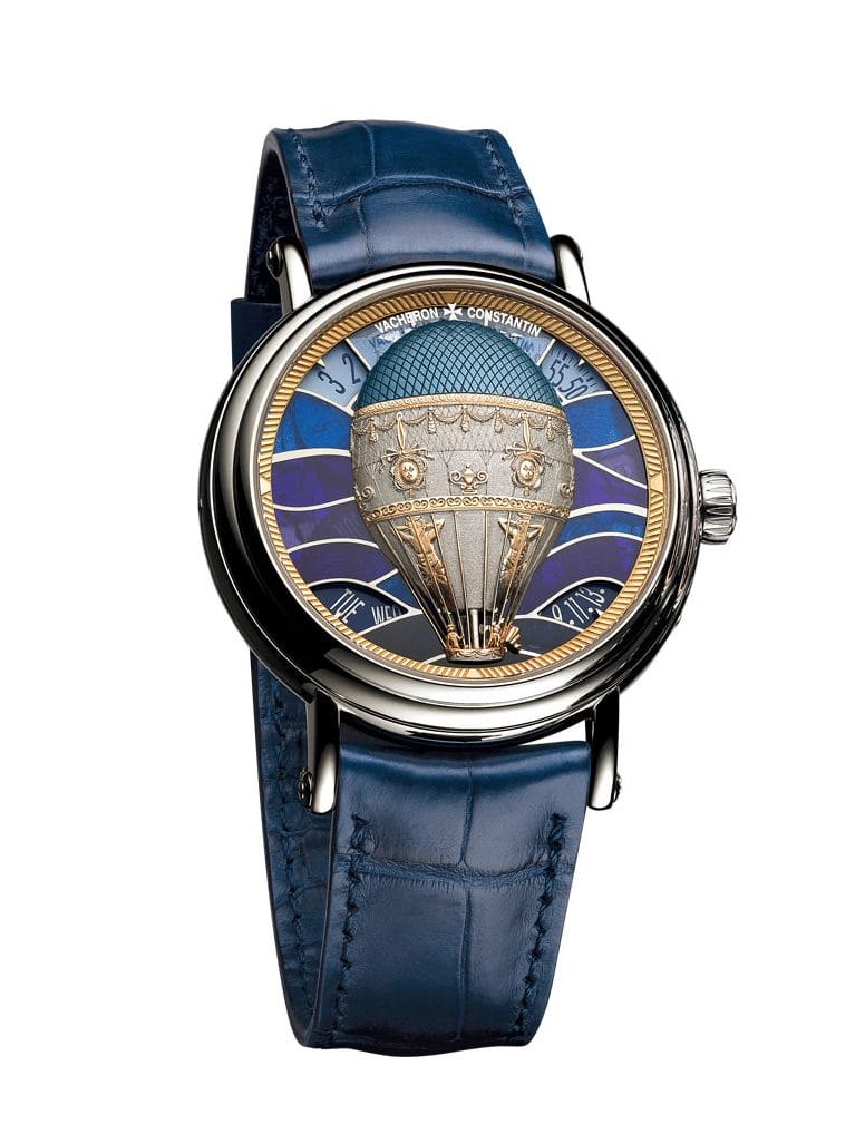Luxury wristwatch with a blue leather strap, featuring a detailed hot air balloon design on the watch face.