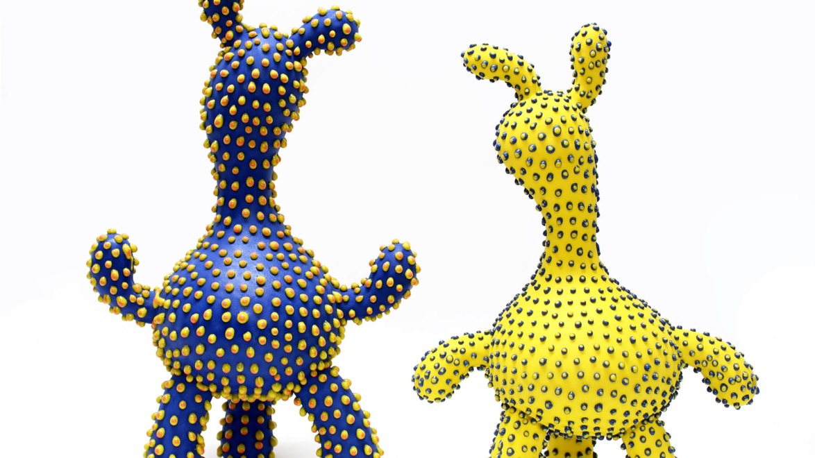 Two colorful abstract sculptures with small protrusions, one blue and one yellow, against a white background.